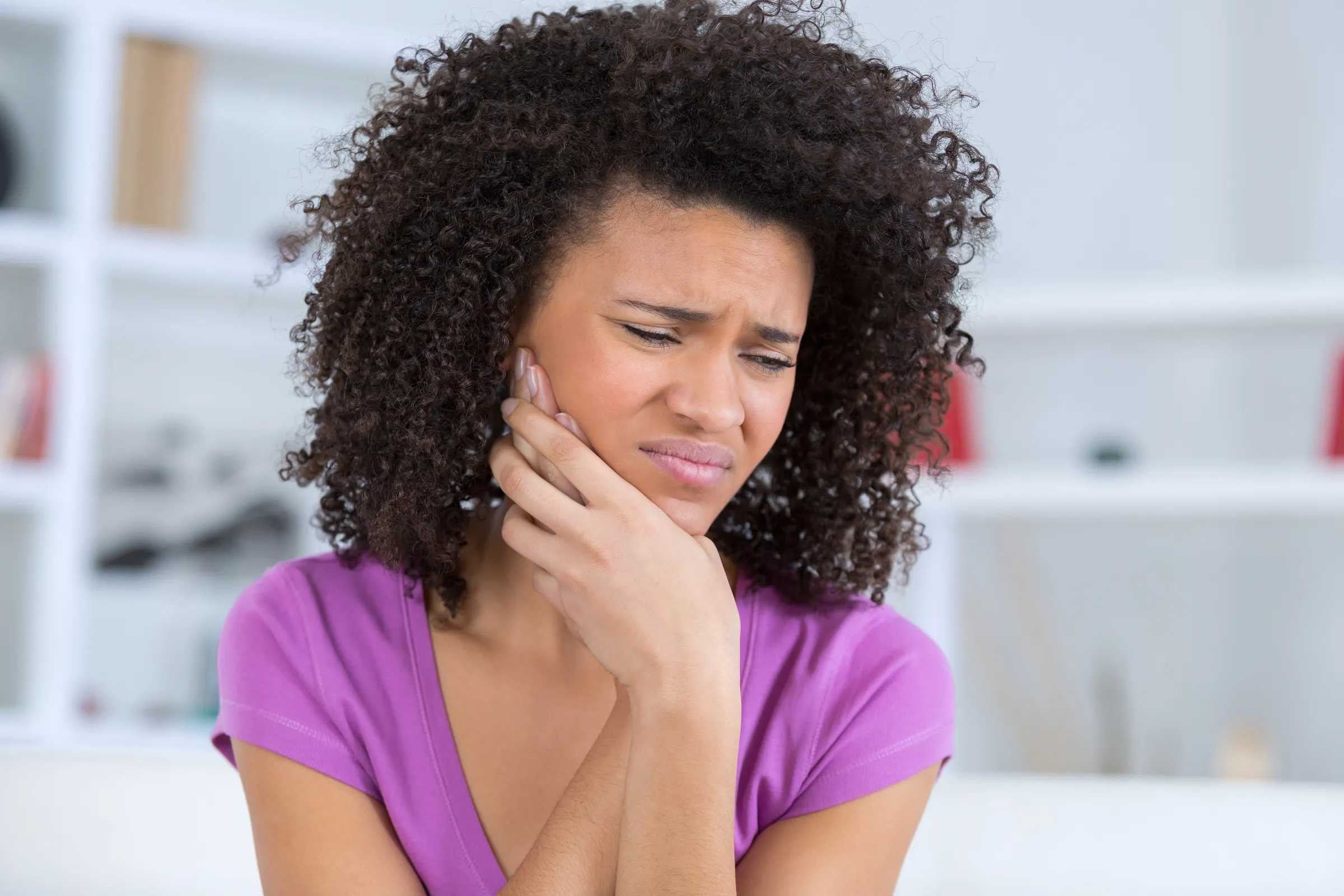 Patient holding their jaw in dental discomfort