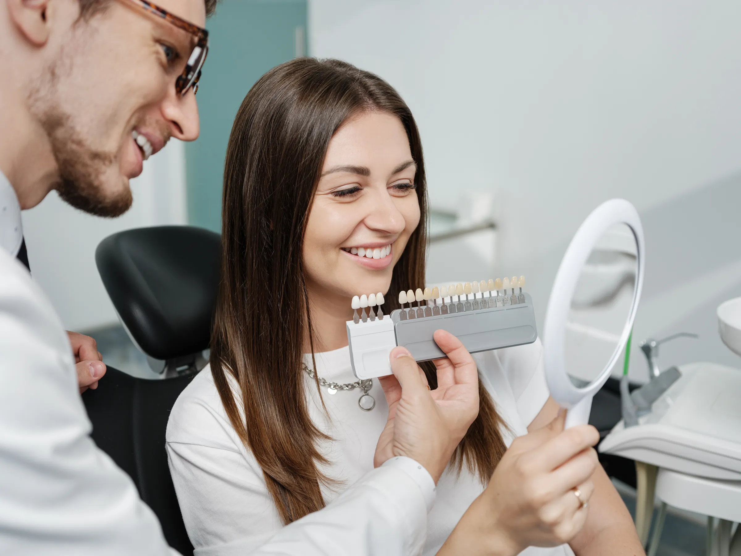 Dentist comparing veneer shade samples with a patient