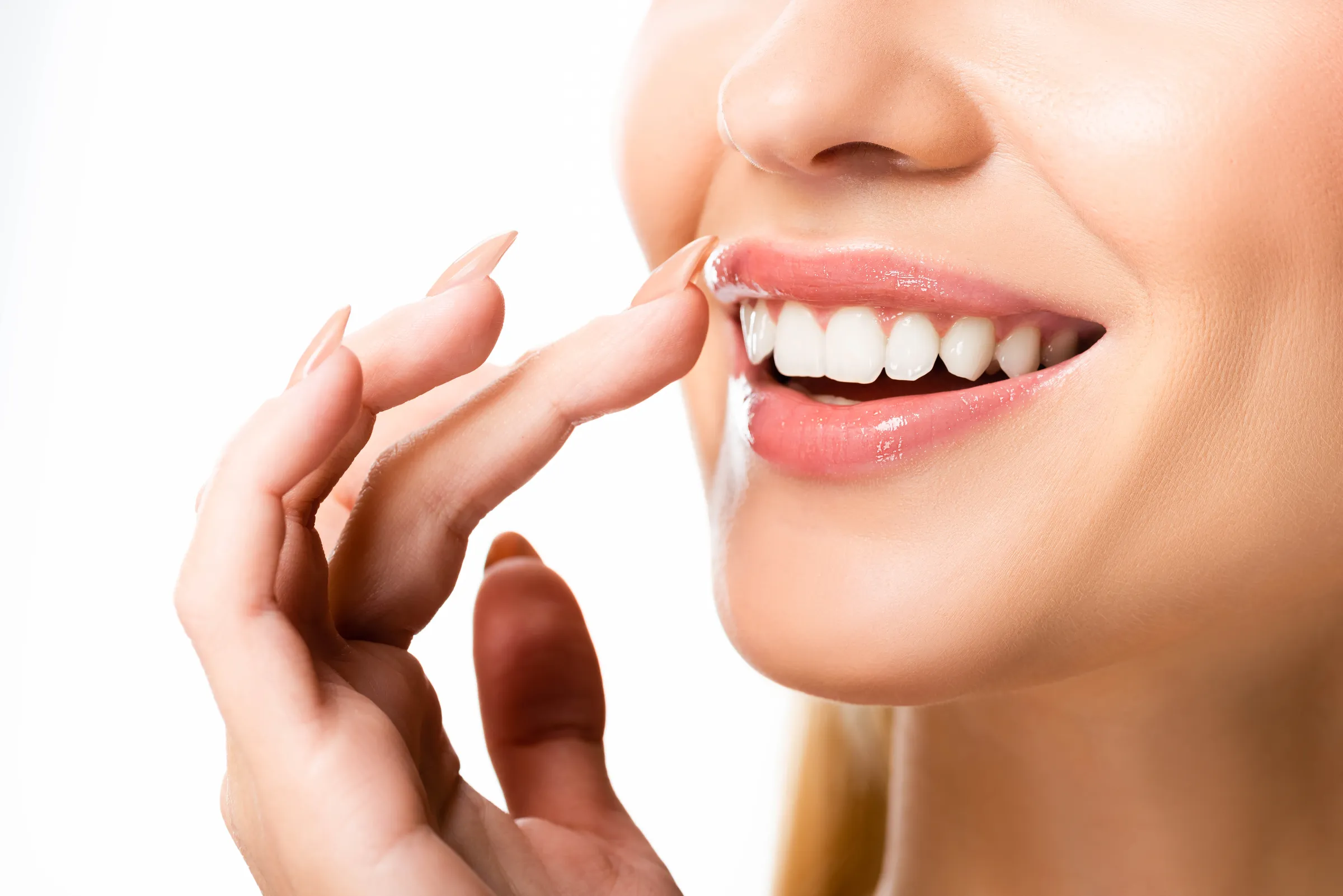 Dentist holding a porcelain veneer up to a patient's smile