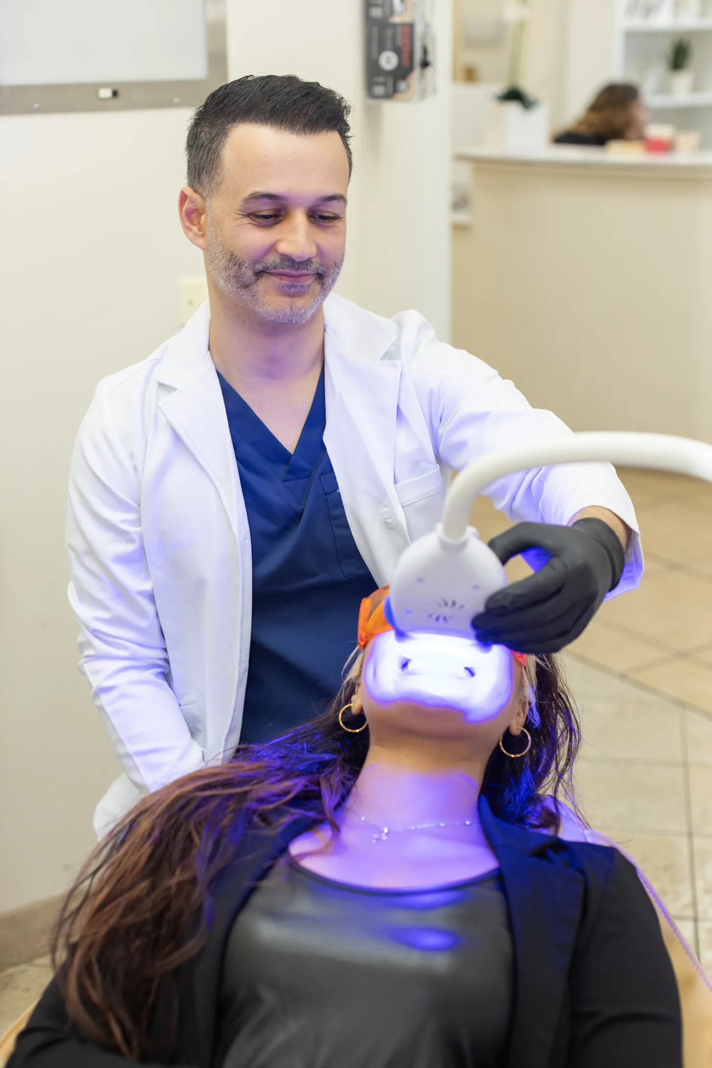 Dr. Poria Edalat performing an in-office whitening treatment